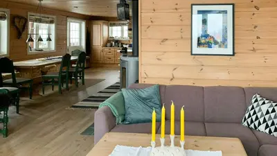 a living room with a couch and a table with yellow candles at Countryside Cabin With Jacuzzi Near Stryn in Sølberg