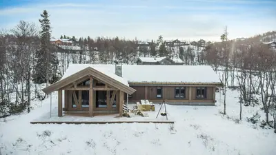 a log cabin with snow on the ground at Modern Log Cabin For Whole Family At Geilo in Geilo