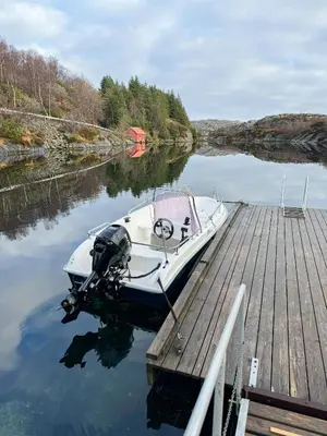 a boat is docked at a dock at Charming Seaside Cabin With Amazing View in Hardbakke
