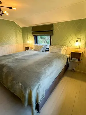 a bedroom with a large bed and a window at Charming Seaside Cabin With Amazing View in Hardbakke
