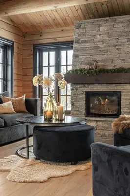 a living room with a table and a fireplace at Modern Log Cabin With Hot Tub And Sauna in Veggli