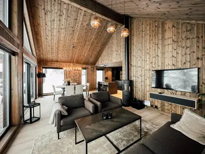 a living room with a couch and a tv at Charming Summer Farm Hut At Sjusjøen in Torpo
