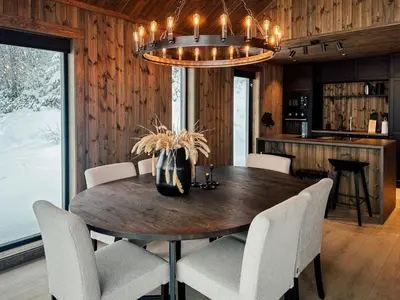 a dining room with a table and chairs and a chandelier at Charming Summer Farm Hut At Sjusjøen in Torpo