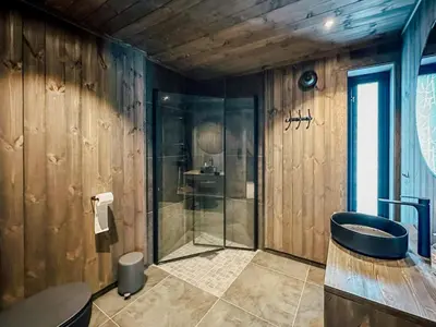 a bathroom with a glass shower and a sink at Charming Summer Farm Hut At Sjusjøen in Torpo