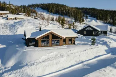a log cabin with snow on the ground at Modern And Inviting Cabin In Valdres in Aurdal