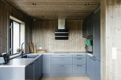 a kitchen with white cabinets and a sink at Modern And Inviting Cabin In Valdres in Aurdal