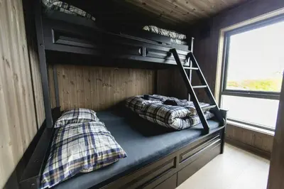 two bunk beds in a room with a ladder at Modern And Inviting Cabin In Valdres in Aurdal
