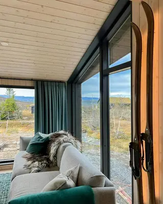 a couch sitting in a room with a window at Stylish Mountain Cabin In Hallingdalen in Flå