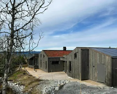 two large wooden buildings with a roof at Stylish Mountain Cabin In Hallingdalen in Flå