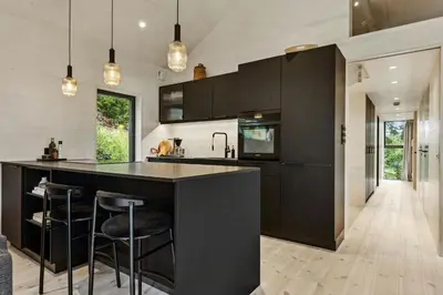 a kitchen with black cabinets and a black island at New Cabin By Tyrifjorden For Relaxing Holidays in Gjesval