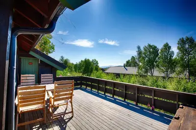 a wooden deck with two benches on a house at A Cozy, Rustic Retreat With Fireplace And Terrace in Beitostøl