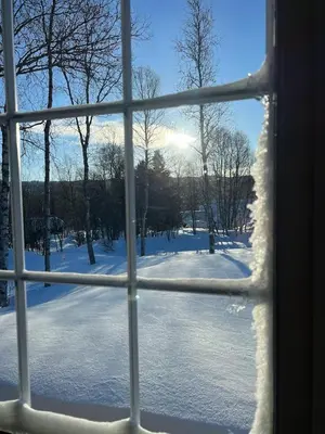 a view of a snow covered field through a window at Charming and cozy cabin in Geilo in Geilo