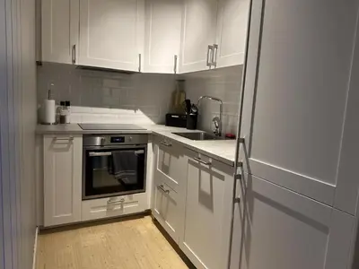 a white kitchen with white cabinets and a refrigerator at Modern 2-Bedroom Apartment In Ideal Location in Beitostøl