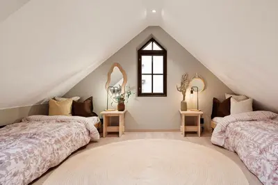 two beds in a attic bedroom with two mirrors at Luxurious Villa in the heart of Bergen with private parking in Bergen