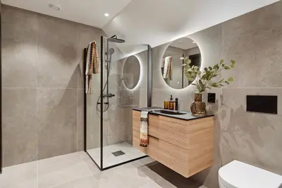 a bathroom with a shower and a sink and a mirror at Luxurious Villa in the heart of Bergen with private parking in Bergen