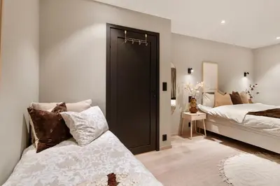 a bedroom with two beds and a black door at Luxurious Villa in the heart of Bergen with private parking in Bergen