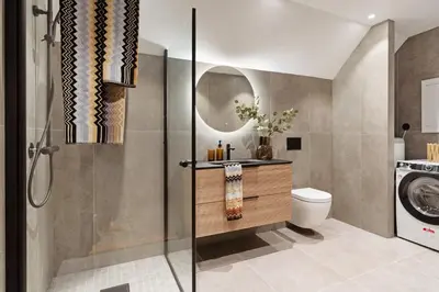 a bathroom with a toilet and a sink and a washing machine at Luxurious Villa in the heart of Bergen with private parking in Bergen