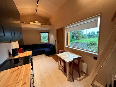 a tiny house with a kitchen and a table at Mikrohus i byen - Tinyhouse Hamar city in Hamar