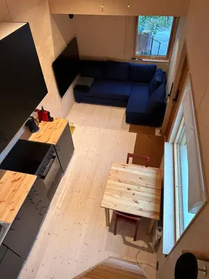 a small living room with a blue couch and a table at Mikrohus i byen - Tinyhouse Hamar city in Hamar