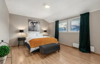 a bedroom with a large bed and green curtains at SKI VM TRONDHEIM 2025- Private home in Tiller