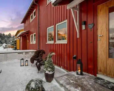 a red house with a christmas tree in front of it at SKI VM TRONDHEIM 2025- Private home in Tiller