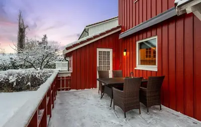 a red house with a table and chairs in the snow at SKI VM TRONDHEIM 2025- Private home in Tiller
