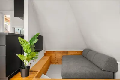 a small living room with a couch and a plant at Bryggen Historical Townhouse I Rooftop Views! in Bergen