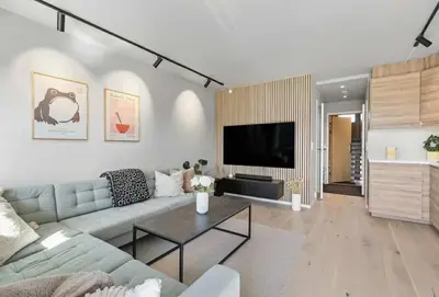 a living room with a couch and a tv at Lys og koselig leilighet leies ut til Ski VM 2025 in Trondheim