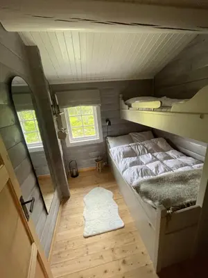 a small room with two bunk beds and a rug at Koselig hytte på Beito in Beitostøl