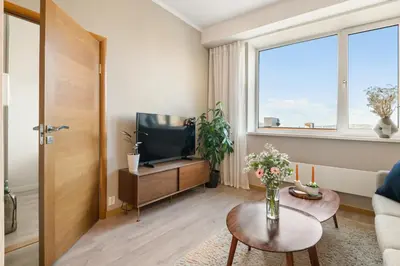 a living room with a television and a table at 3-roms leilighet i hjertet av Sandviken in Bergen