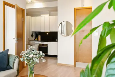 a living room with a vase of flowers on a table at 3-roms leilighet i hjertet av Sandviken in Bergen