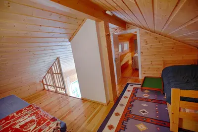 an attic room with a bed and a large window at Ski-In Ski-Out Cozy Retreat With Mountain Views in Beitostøl
