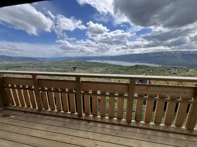a wooden deck with a view of a lake at Ski-In Ski-Out Cozy Retreat With Mountain Views in Beitostøl