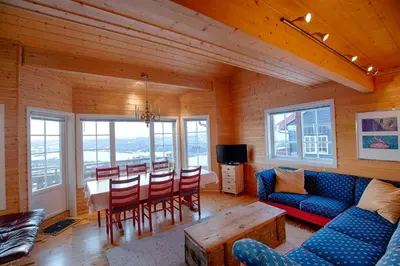 a living room with a couch and a table and chairs at Ski-In Ski-Out Cozy Retreat With Mountain Views in Beitostøl