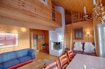 a living room with a blue couch and a table at Ski-In Ski-Out Cozy Retreat With Mountain Views in Beitostøl