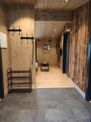 a hallway with wooden walls and a room with a table at Nye leiligheter på Blomberg i Hafjell in Hafjell