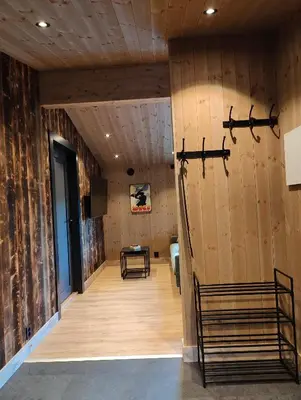 a room with a wooden wall and a table at Nye leiligheter på Blomberg i Hafjell in Hafjell