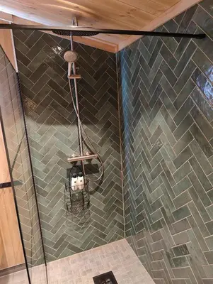 a shower in a bathroom with a tiled wall at Nye leiligheter på Blomberg i Hafjell in Hafjell