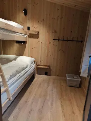 a small room with a bed and a wooden wall at Nye leiligheter på Blomberg i Hafjell in Hafjell