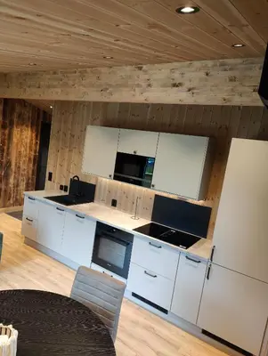 a kitchen with white cabinets and a stove top oven at Nye leiligheter på Blomberg i Hafjell in Hafjell