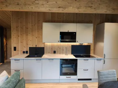 a kitchen with white cabinets and a microwave at Nye leiligheter på Blomberg i Hafjell in Hafjell