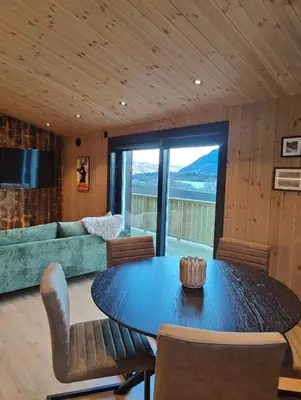 a living room with a table and a couch at Nye leiligheter på Blomberg i Hafjell in Hafjell