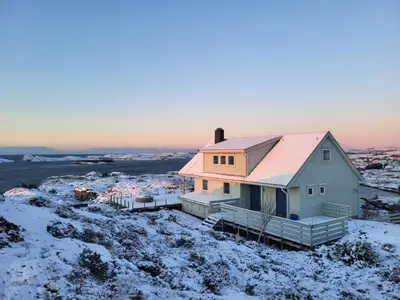 a house with a pink roof in the snow at Stor hytte med fantastisk utsikt in Vikso