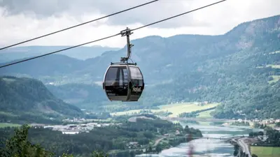a cable car flying over a valley in the mountains at Apartment at Hafjell by Gaia ski-in out in Hafjell