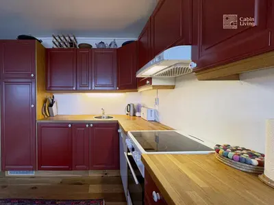 a kitchen with dark red cabinets and a sink at Apartment at Hafjell by Gaia ski-in out in Hafjell