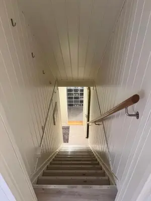 a staircase in a house with a white wall at Cozy apartment on the hill in Trondheim