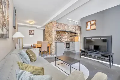 a living room with a couch and a television at Bryggen Nest in Bergen