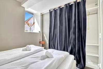 a bedroom with two beds and a window at Bryggen Nest in Bergen