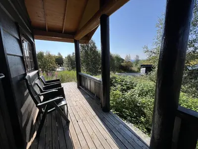 a porch with two benches sitting on a house at Nostalgic Cabin With 3 Br, Fireplace, And Terrace in Beitostøl