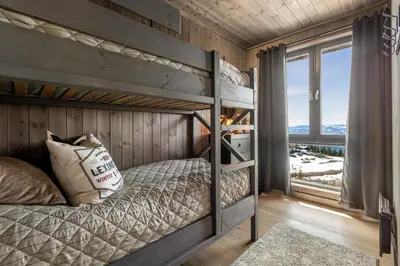 a bedroom with two bunk beds and a window at New modern apartment with ski in out in Hafjell in Hafjell